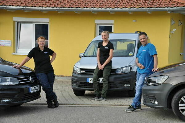 3 Leute neben Autos 3 Leute neben Autos